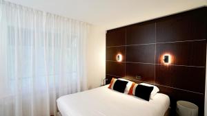 - une chambre avec un lit et une tête de lit en bois dans l'établissement Boutique Logis Hôtel Relais de Vincey, à Vincey