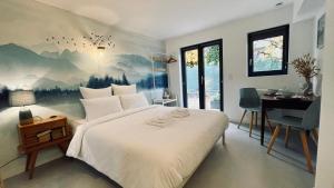 - une chambre avec un grand lit orné d'une peinture murale dans l'établissement Le Chalet de la Plage, à Sévrier