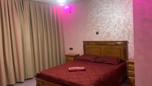 a bedroom with a bed with a red comforter at Chic 3 Bed Villa in heart of Agadir in Agadir