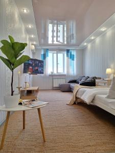 una camera con letto e tavolo con pianta di Велике ліжечко на Садовому. Мережа Alex Apartments. Цілодобове безконтактне заселення a Poltava