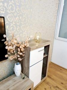 un tavolo con un vaso di fiori in una stanza di Esperanto a Vranje