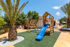 a playground with a slide and a palm tree at Villa Joan - PlusHolidays in Calpe