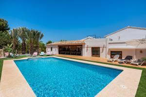 a villa with a swimming pool in front of a house at Villa Joan - PlusHolidays in Calpe