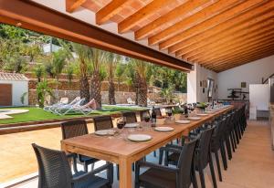 długi drewniany stół i krzesła na patio w obiekcie Villa Joan - PlusHolidays w mieście Calpe