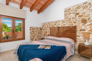 sypialnia z łóżkiem i kamienną ścianą w obiekcie Villa Joan - PlusHolidays w mieście Calpe +37 zdjęć
