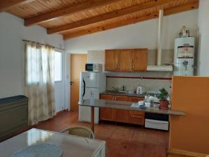 a kitchen with wooden cabinets and a white refrigerator at Departamento en Barrio Los Olmos in Trelew