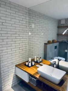 a bathroom with a sink and a white brick wall at KOMFORTOWY,JASNY APARTAMENT dla max 4-5 osób in Łódź