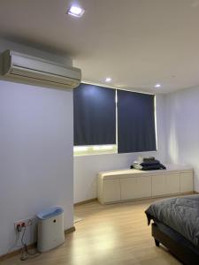 a bedroom with a bed and a window with blue blinds at 118 Apartment Tanjung Tokong by Yen's Sojourn in George Town +10 photos