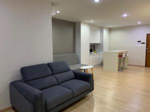 a living room with a blue couch and a kitchen at 118 Apartment Tanjung Tokong by Yen's Sojourn in George Town