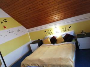 ein Schlafzimmer mit einem Bett mit gelben Wänden in der Unterkunft Fitt Vendégház in Sümeg