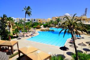 Hôtel Joya Paradise & SPA Djerba في Djerba: مسبح فيه مظلات والنخيل في منتجع