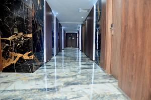 um corredor de um hotel com piso em mármore e paredes de madeira em Hôtel Joya Paradise & SPA Djerba em Djerba
