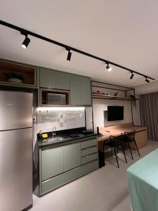 uma cozinha com um frigorífico e uma mesa com cadeiras em Barra Premium residencial em Salvador