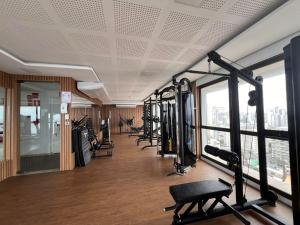 a gym with a row of treadmills and machines at Barra Premium residencial in Salvador