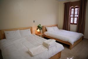 - une chambre avec 2 lits et une fenêtre dans l'établissement Tom's House Motel & Motorbikes, à Làng Me