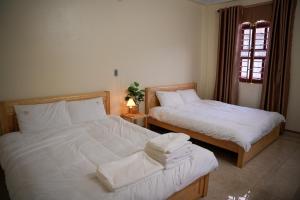Làng MeにあるTom's House Motel & Motorbikesのベッド2台と窓のある寝室 +11枚の写真