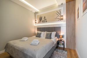 a bedroom with a large bed with two towels on it at Q18 ApartHotel in Bydgoszcz