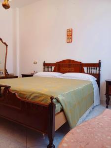 ein Schlafzimmer mit einem Bett mit einer grünen Decke darauf in der Unterkunft Casa Ciusa in Quartu SantʼElena