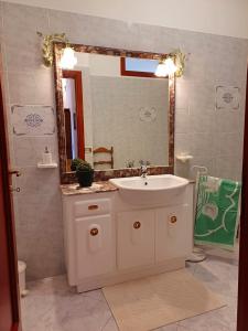 ein Bad mit einem Waschbecken und einem Spiegel in der Unterkunft Casa Ciusa in Quartu SantʼElena