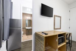 Cette chambre comprend un réfrigérateur et un bureau avec un miroir. dans l'établissement Hotel 27 by LuxUrban, à New York