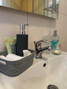 a bathroom sink with a basket of towels and a faucet at Apartmány F - chata SVOBODĚNKA in Dolní Moravice