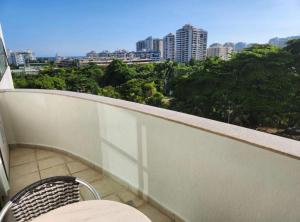 balcón con silla y vistas a la ciudad en Flat Mediterrâneo.2, en Río de Janeiro