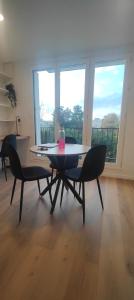 een eetkamer met een tafel en stoelen en een balkon bij Grand studio proche de Paris in Saint-Maur-des-Fossés