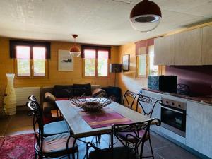 a kitchen and dining room with a table and chairs at Les hirondelles in Ollon