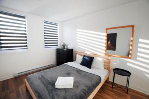 ein Schlafzimmer mit einem Bett und einem Stuhl darin in der Unterkunft Le 1066 - Logement spacieux à Limoilou in Québec