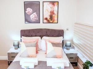 1 dormitorio con 1 cama con almohadas rosas y blancas en Shrewsbury apartments by BEVOLVE - Free Parking, en Shrewsbury