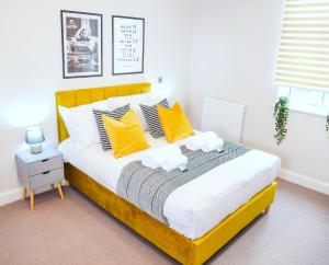 1 dormitorio con 1 cama grande con almohadas amarillas en Shrewsbury apartments by BEVOLVE - Free Parking, en Shrewsbury