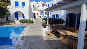 un patio con tavolo e sedie accanto alla piscina di Capari Maisonette Mykonos Town Villa with Shared Pool a Mykonos Città