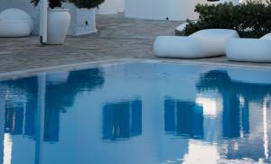 una piscina con acqua blu in un cortile di Capari Maisonette Mykonos Town Villa with Shared Pool a Mykonos Città Altre 35 foto