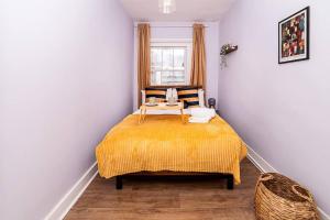 a bedroom with a bed with a yellow blanket at [Covent Garden-Oxford Street] Central London Apartment in London