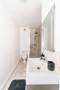 Baño blanco con lavabo y aseo en [Covent Garden-Oxford Street] Central London Apartment, en Londres