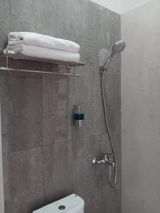 y baño con ducha, aseo y toallas. en 44 Guest House Syariah en Purwokerto