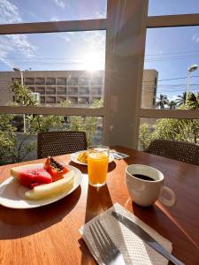 uma mesa com um prato de comida e um copo de sumo de laranja em ibis budget Aracaju em Aracaju