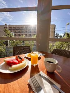 a table with a plate of food and a glass of orange juice at ibis budget Aracaju in Aracaju