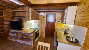 a kitchen in a log cabin with a counter at Siedlisko nad jeziorem Skarlińskim 5B, mazury, jezioro, domek, bania in Kurzętnik