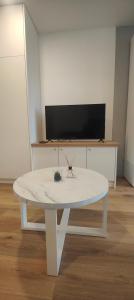 een witte salontafel in een kamer met een tv bij Grand studio proche de Paris in Saint-Maur-des-Fossés