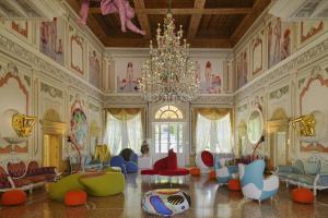 a large room with colorful chairs and a chandelier at Byblos Art Hotel Villa Amistà in San Pietro in Cariano