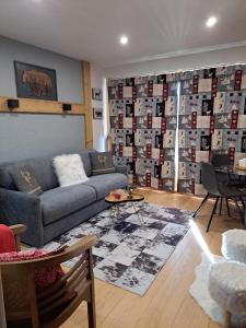 a living room with a couch and a table at STUDIO 2 ALPES STYLE CHALET au PIED DE TELESIEGE DU DIABLE in Les Deux Alpes