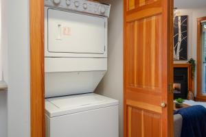 a kitchen with a refrigerator and a washer and dryer at 2BR Very Spacious Townhome in a Great Location by Harmony Whistler in Whistler