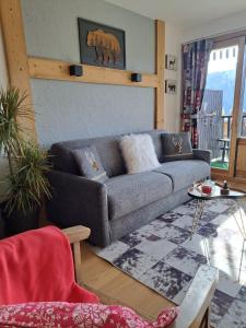 a living room with a couch and a table at STUDIO 2 ALPES STYLE CHALET au PIED DE TELESIEGE DU DIABLE in Les Deux Alpes