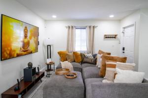a living room with a gray couch and a large painting at Good Vibes Oasis - Cozy townhome with parking in Cutler Bay
