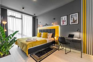 a bedroom with a bed and a desk with a laptop at Q18 ApartHotel in Bydgoszcz