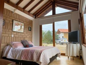 een slaapkamer met een bed en een groot raam bij Casa campestre Las Flores in Villa de Leyva