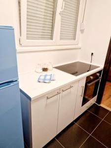 a white kitchen with a sink and a refrigerator at Esperanto in Vranje