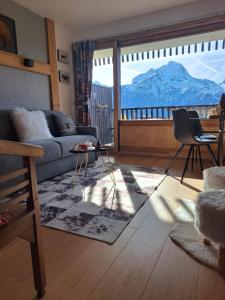 a living room with a couch and a view of a mountain at STUDIO 2 ALPES STYLE CHALET au PIED DE TELESIEGE DU DIABLE in Les Deux Alpes