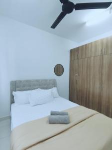 una camera con letto bianco e ventilatore a soffitto di The Ken & Hiro Stay a Sepang